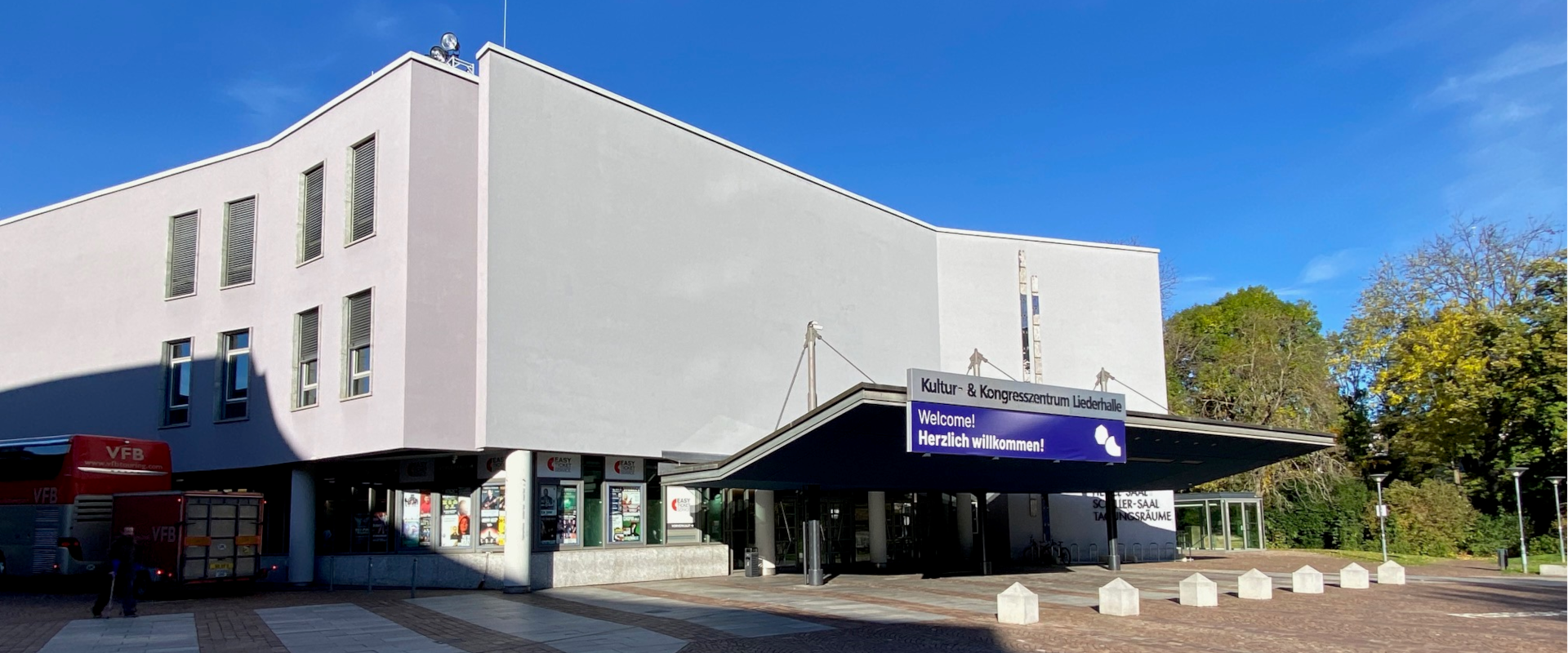 Gebäude mit Vordach; Leuchtschrift „Kultur- & Kongresszentrum Liederhalle“ und Display „Welcome! Herzlich willkommen!“