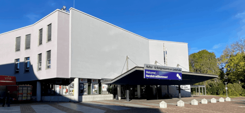 Gebäude mit Vordach; Leuchtschrift „Kultur- & Kongresszentrum Liederhalle“ und Display „Welcome! Herzlich willkommen!“
